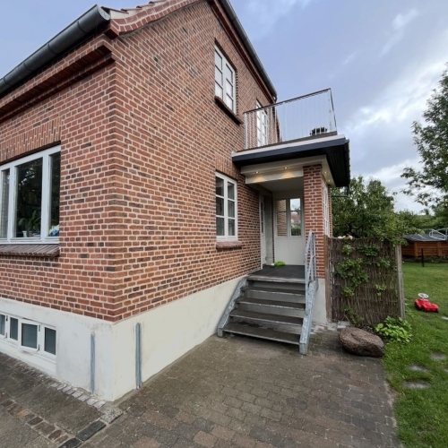 Facaderenovering på Amager med omfugning af murværk ved indgangsparti.