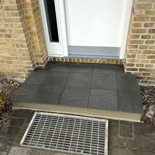 Flisearbejde ved indgang i Kastrup med nye flisetrin.