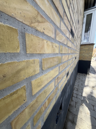 Close-up af omfugning af murværk ved facaderenovering i Kastrup på Amager.