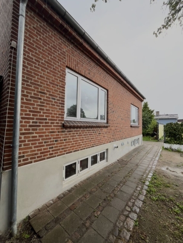 Facaderenovering på Amager med omfugning af murværk og pudset sokkel.