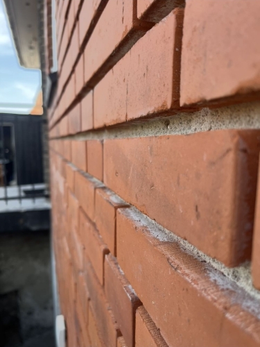 Close-up af facaderenovering på Amager med omfugning af murværk.