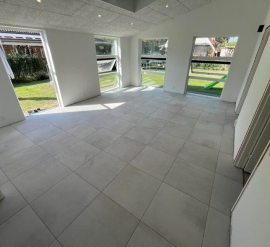 Flisearbejde i opholdsrum i Tårnby med lyse gulvfliser.