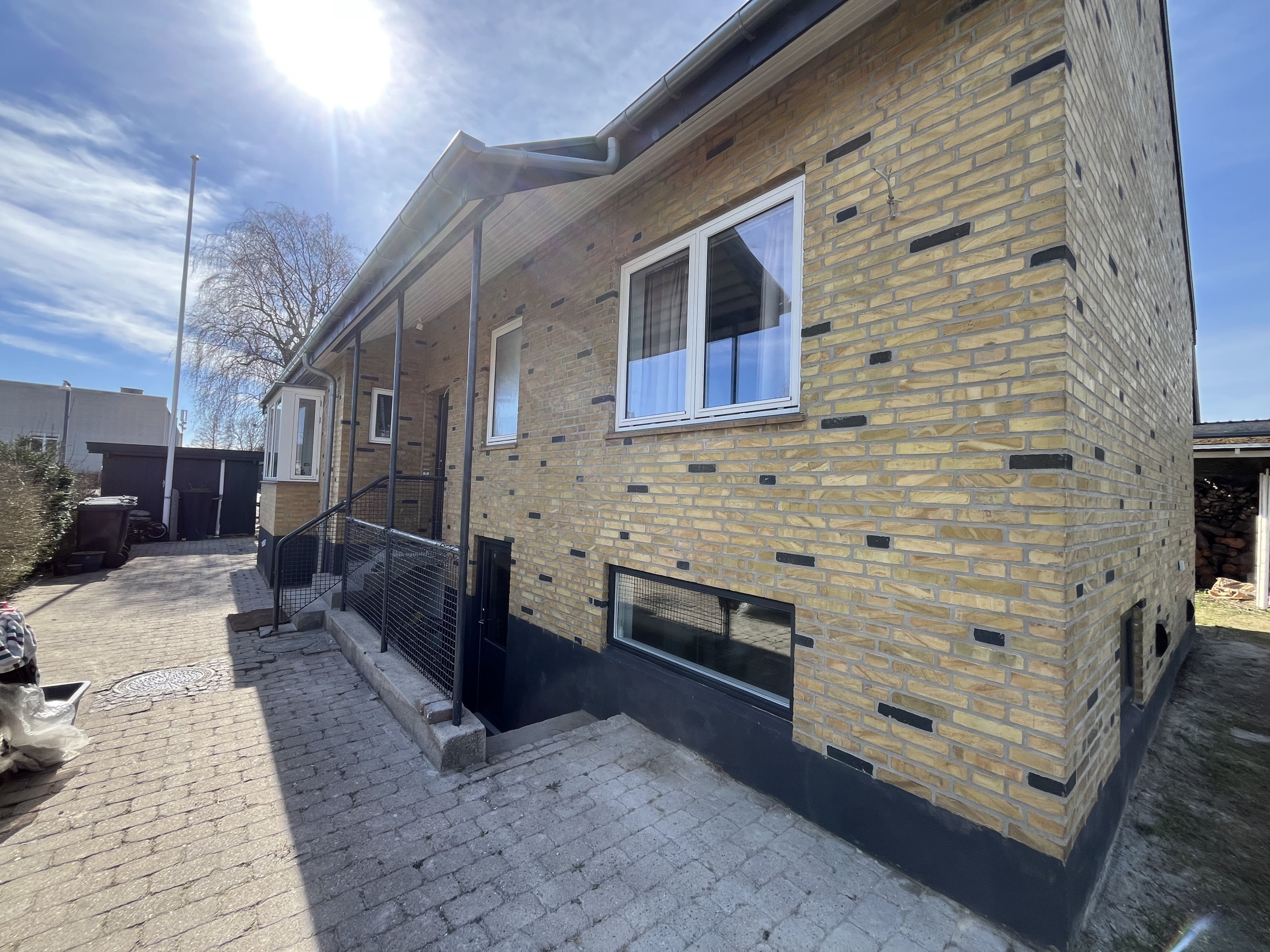 Facaderenovering i Kastrup, Amager med omfugning af murværk og sort sokkel.