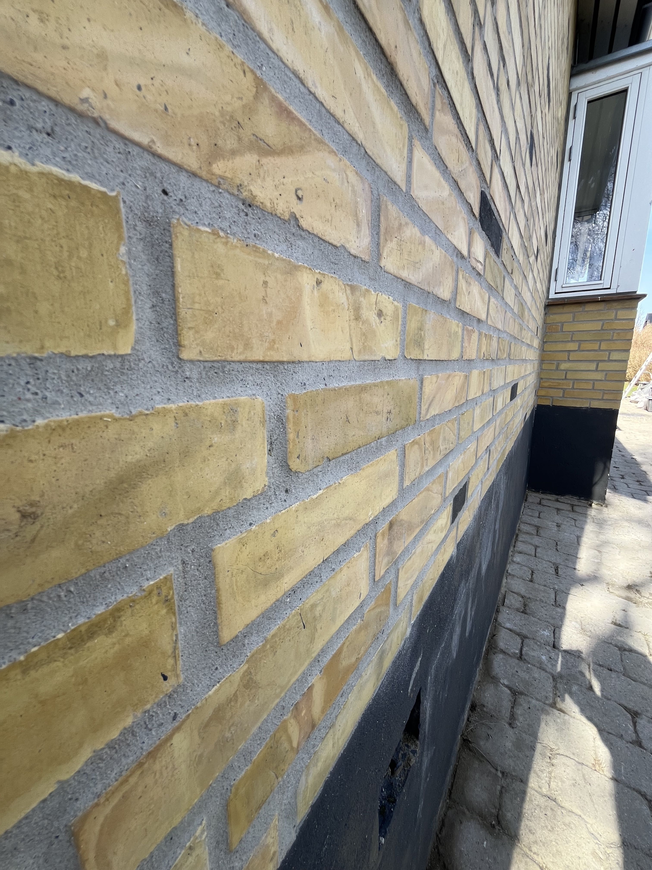 Close-up af omfugning af murværk ved facaderenovering i Kastrup på Amager.