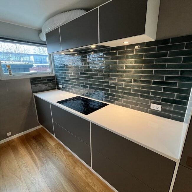 Flisearbejde i køkken i Dragør med mørke vægfliser.
